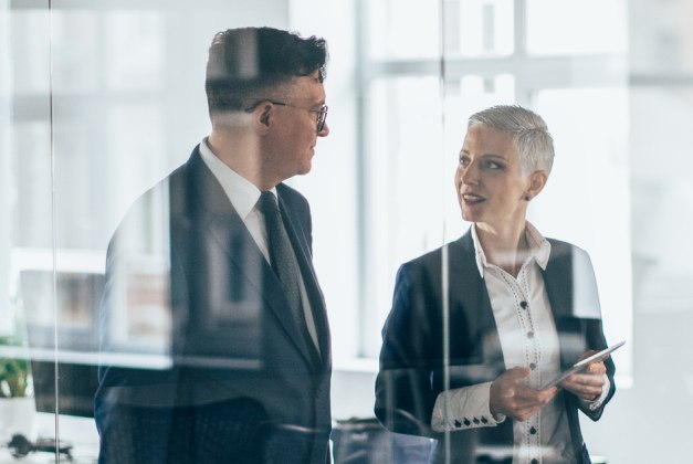 Zwei Personen unterhalten sich in einem Büro 