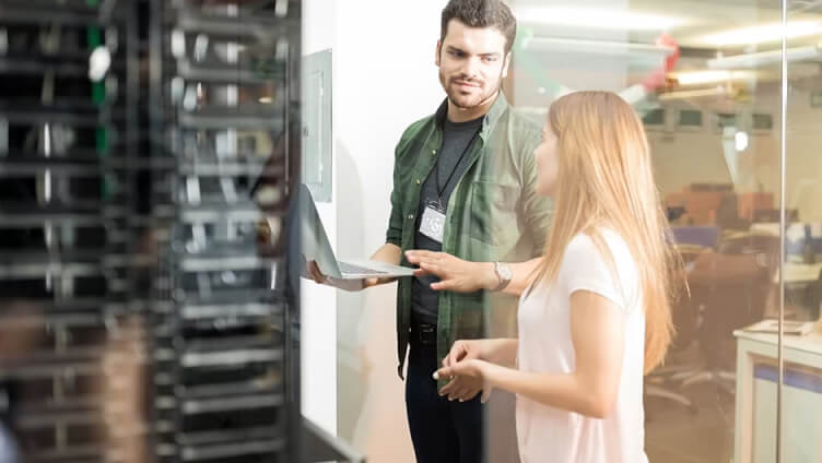 Personen mit Laptop im Datacenter-Raum, die diskutieren