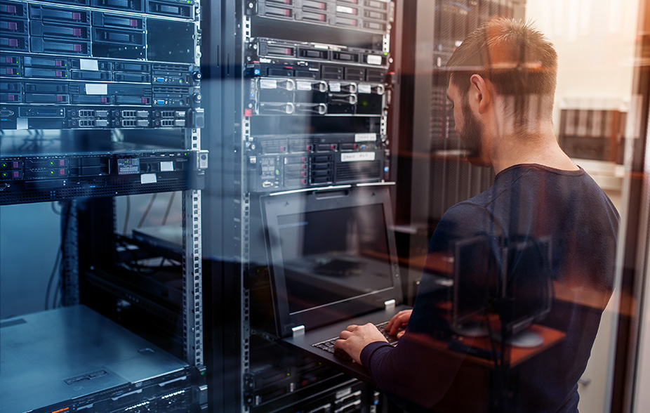 Person, die an einem Server-Terminal-Monitor arbeitet