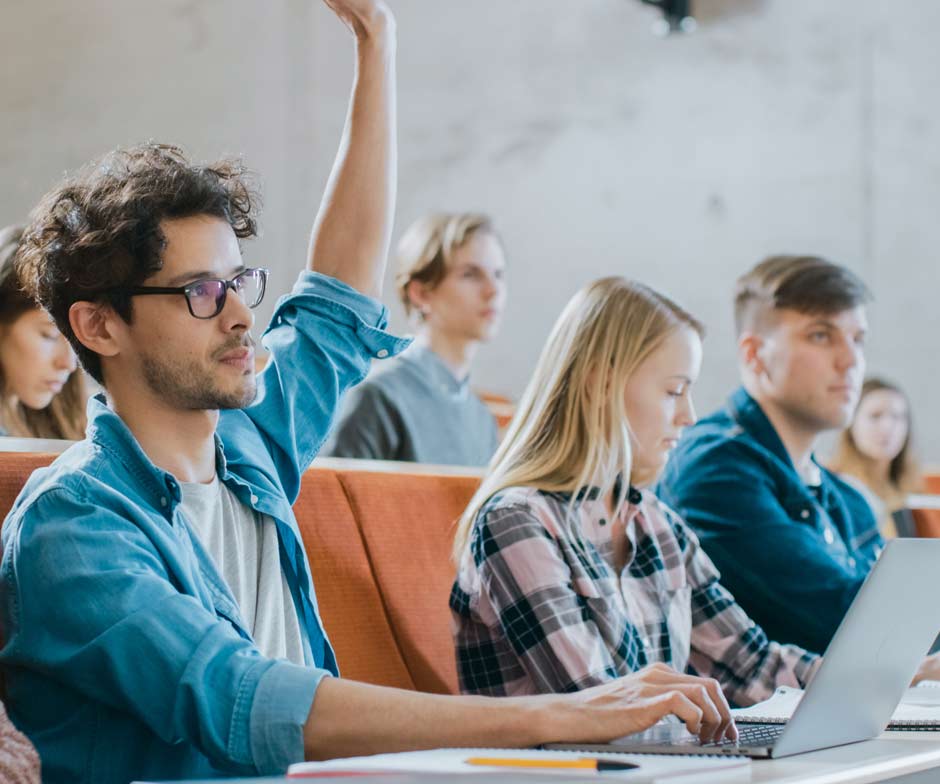 Studenten heben die Hand in einem Unterrichtsraum