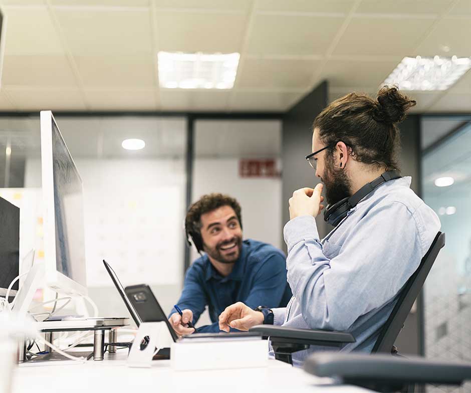 dos chicos sentados y charlando en el escritorio de la oficina