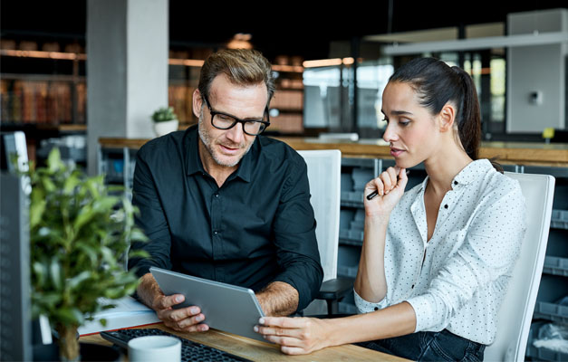 dos personas trabajando con una tableta