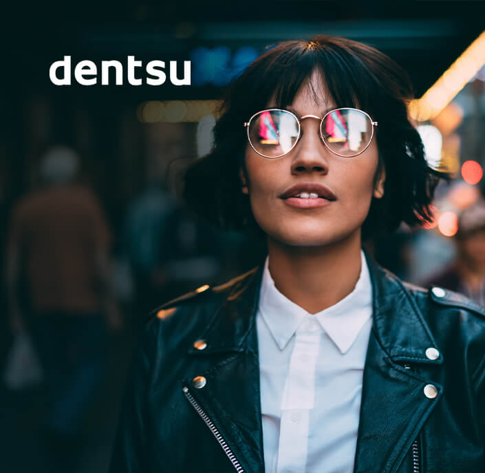 logo Dentsu et personne portant des lunettes