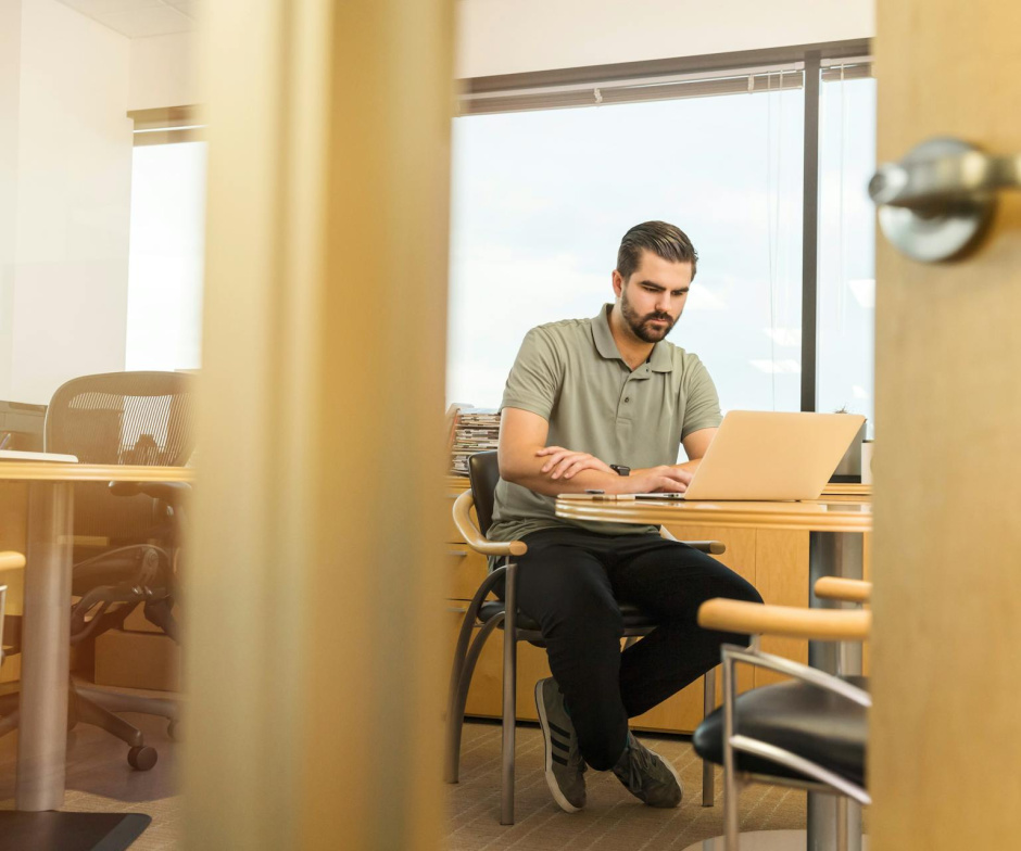 Personne assise et travaillant sur un ordinateur portable