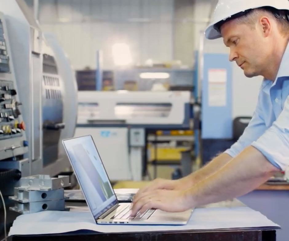 Homme travaillant sur un ordinateur portable dans un chapeau dur