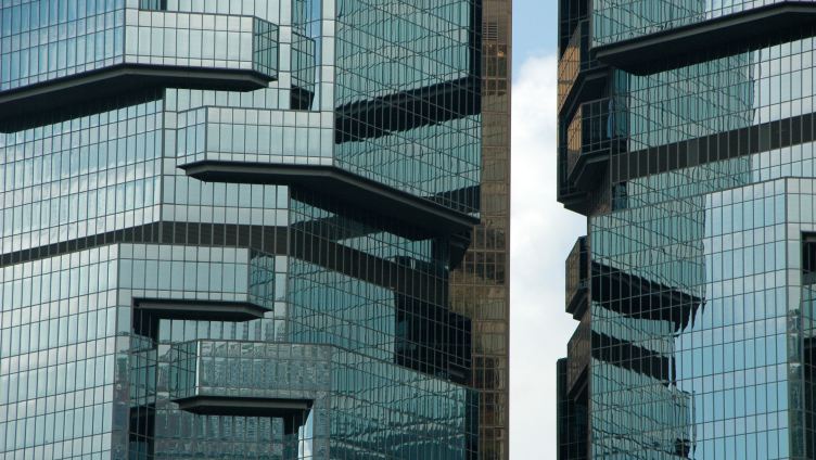 edificio in vetro con ombre riflesse che creano un effetto a specchio