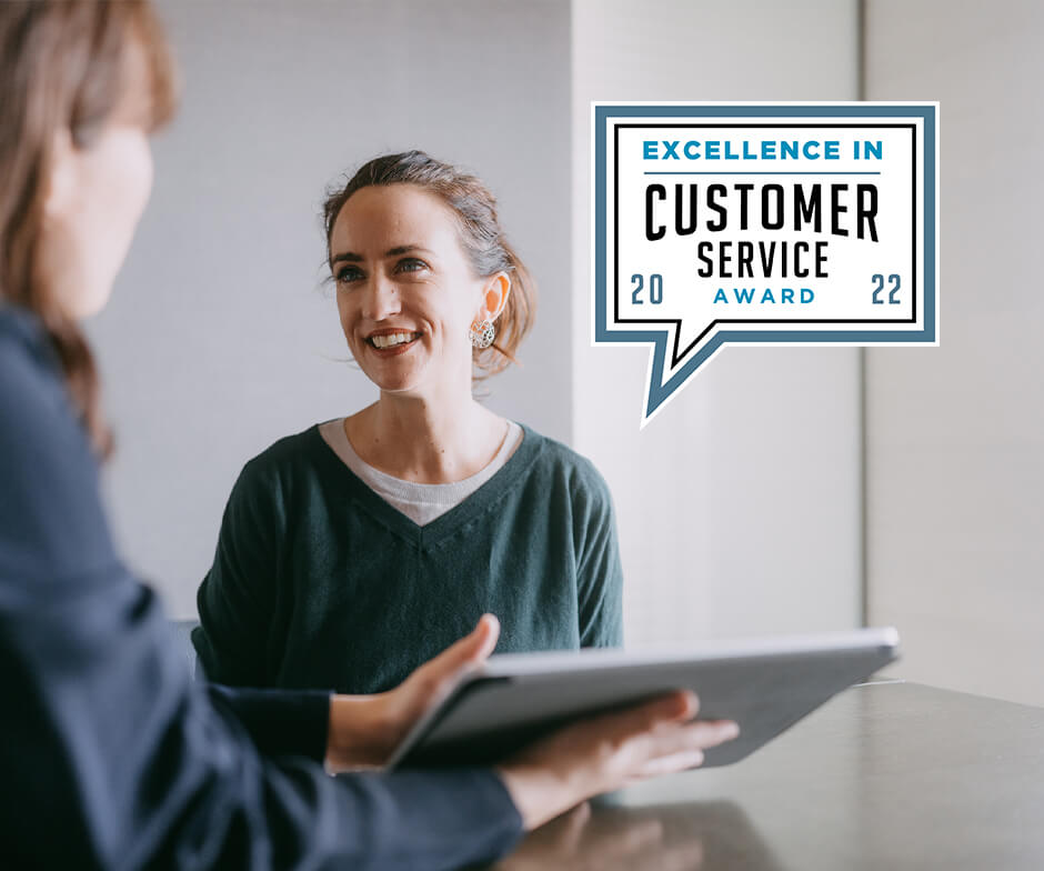 Business Intelligence GroupのCustomer Service Awardのロゴを使用した仕事について話している2人の女性