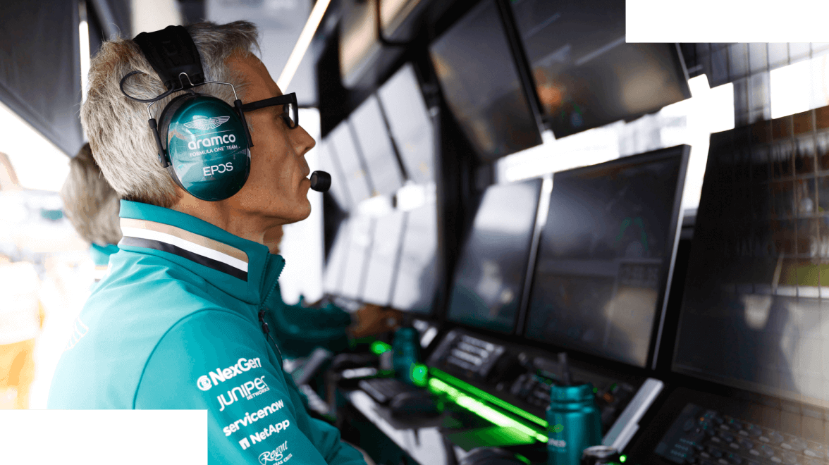 Aston Martin F1 F1 피트 크루 멤버가 성능을 평가하기 위해 화면을 바라보는 측면 프로필 샷
