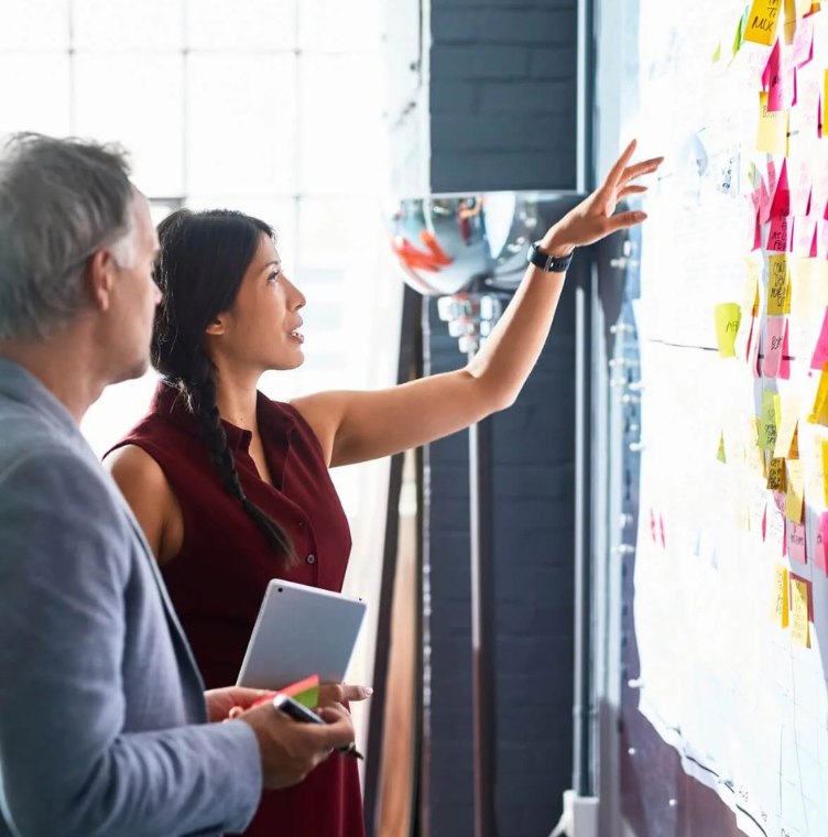 people discussing looking at sticky notes on board