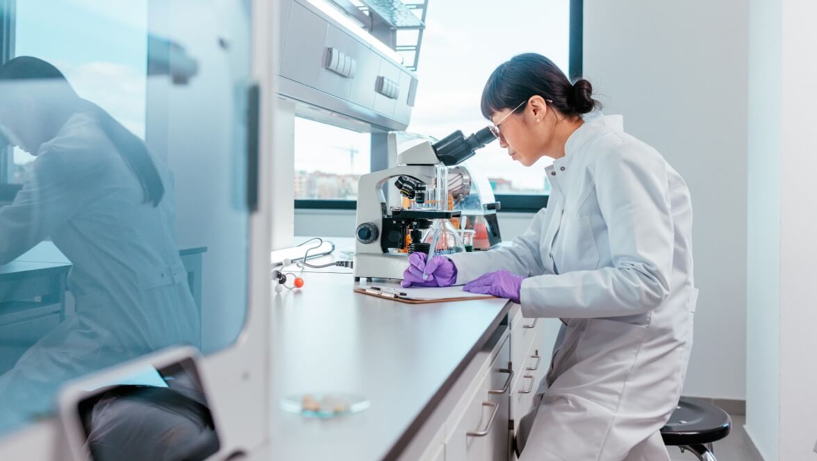 scientist looking into microscope