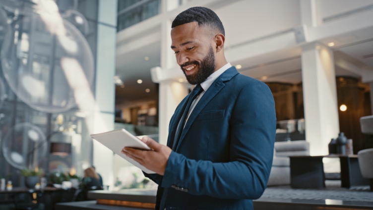 person wwearing suit and looking at mobile tablet and analyzing