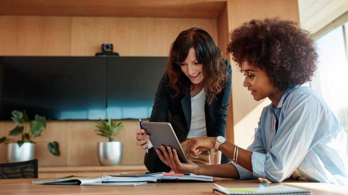 Duas pessoas olhando para o iPad e conversando