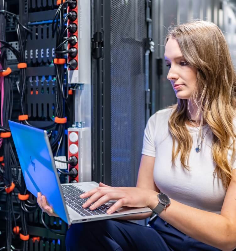Mulher com laptop em um data center