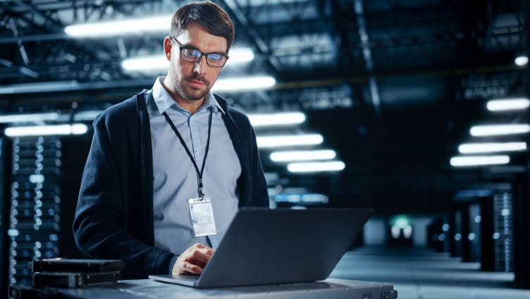 Prfoessional usando cartão de identificação da empresa e olhando para o laptop