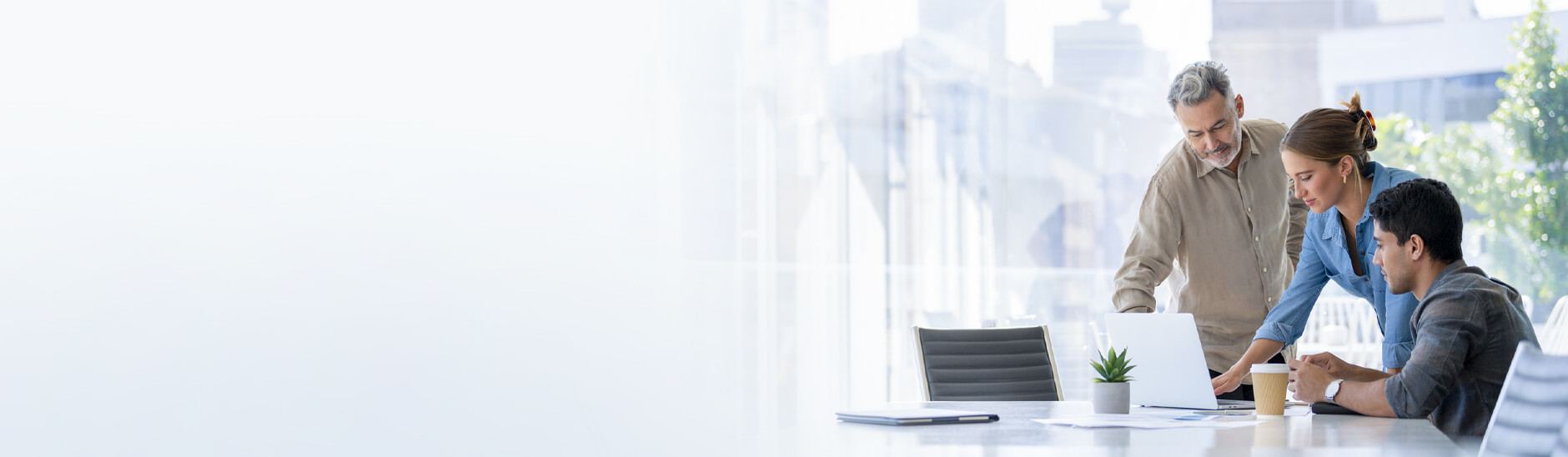 三个人站在笔记本电脑周围